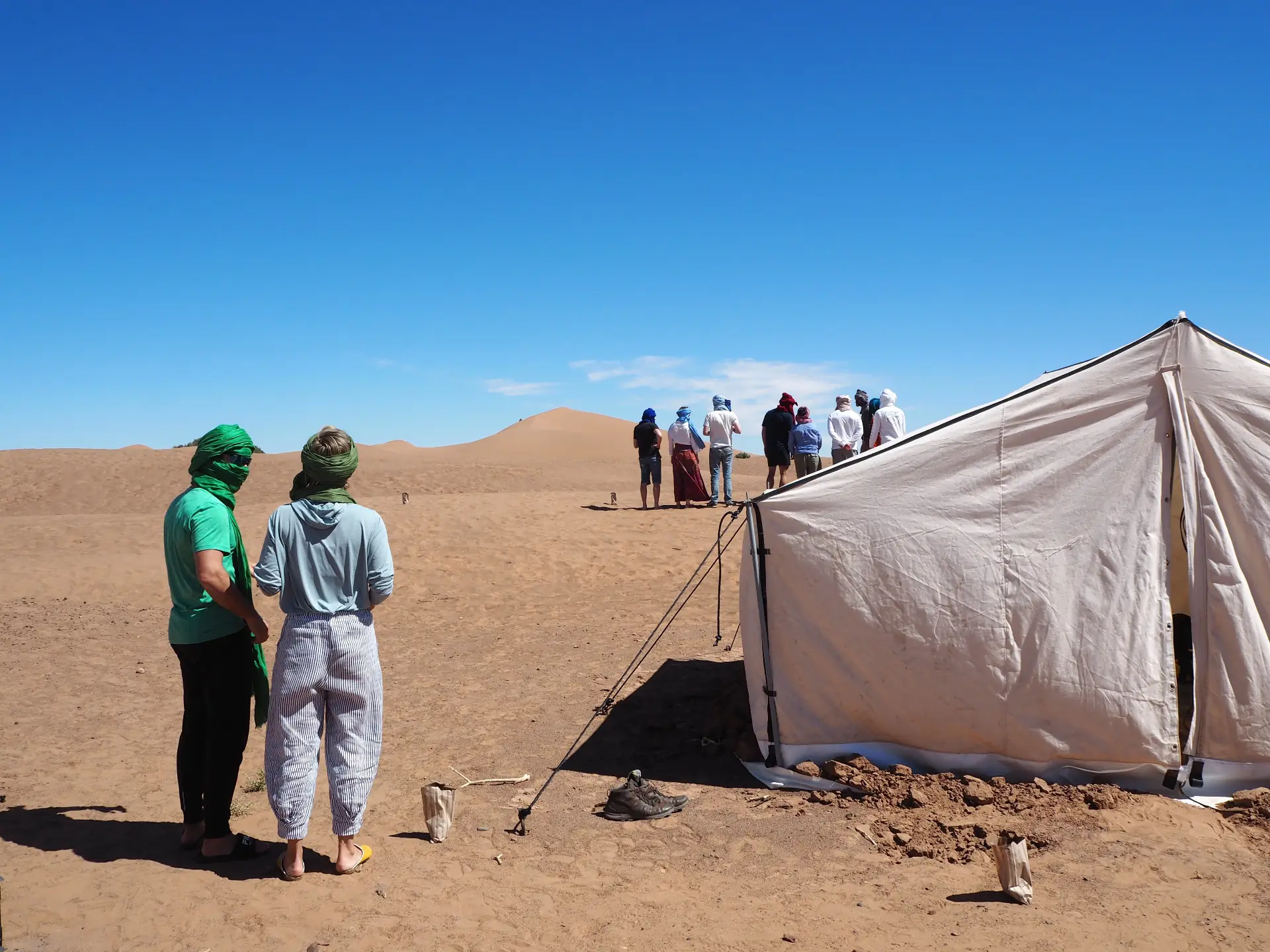 A small group walking beside a Sahara dune